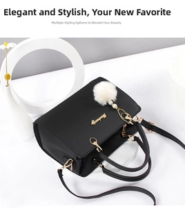 Elegant black leather handbag with a plush fur ball charm and golden logo detail