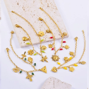 Détail de bracelets bohèmes dorés avec perles colorées et breloques soleil et croix
