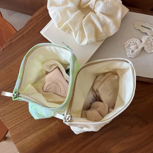 Detailed top view of compact makeup bags with open zippers showing stored cosmetics