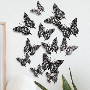 Close-up of 12 black hollow butterfly wall stickers with 3D wings on a white wall