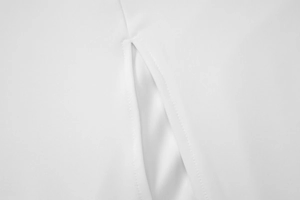 Detail shot of the white summer dress featuring precise stitching and side slit texture