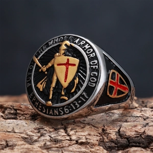 Macro detail of knight shield ring with red cross and Bible verse on tree bark background