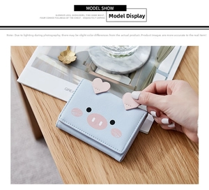 Detail of light blue tri-fold wallet with cute cartoon pig ears and heart-shaped accent