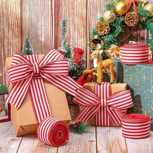 Dettaglio di nastri a righe bianche e rosse annodati su scatole regalo di Natale