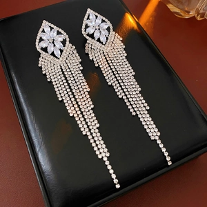 Detail of silver drop earrings with floral crystal stud and long rhinestone tassels