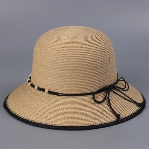 Detailansicht der feinen Raffia-Struktur mit Holzperlen und schwarzer Schleife