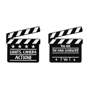 Movie clapboard enamel pin set with inspirational text on a clean white background
