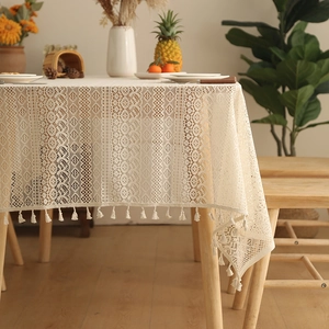 Detail of bohemian lace tablecloth with geometric hollow patterns and fringe tassels