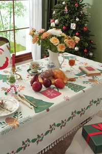 Detail of Christmas tablecloth with fringe, festive tree prints and holiday text patterns