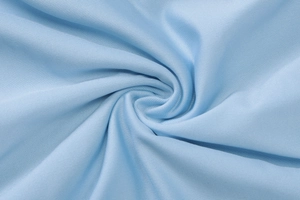 Dettaglio macro del tessuto twill azzurro con trama fitta e consistenza morbida