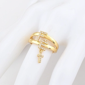 Detail of gold double-layer ring with F letters and pavé zircon cross charm pendant