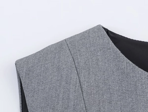 Close-up of grey crinkled fabric texture and stitching details on the women's vest