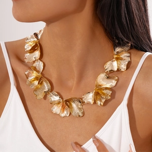 Detail of gold petal necklace featuring textured metallic finish and bold floral shapes