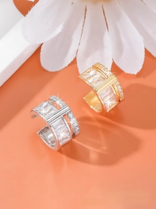 Detail of elegant gold and silver double-layered ear cuffs with sparkling zircons