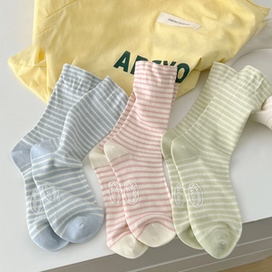 Three pairs of striped crew socks in blue pink and green pastel colors on white surface