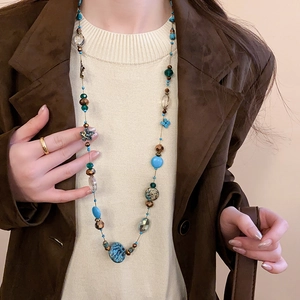 Detail of layered bohemian beaded necklace with turquoise and crystals on model