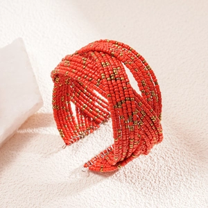 Detail shot of multilayer woven red seed beads and brass accents on a bohemian cuff bracelet