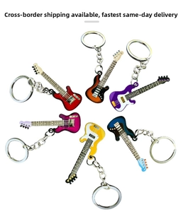 Close-up of colorful electric guitar keychains in red, blue, and sunburst finishes