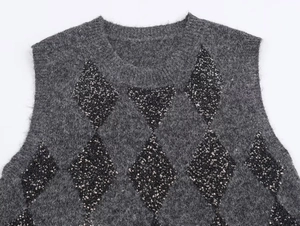 Detalle de chaleco de punto gris oscuro con patrones de diamantes de lentejuelas negras