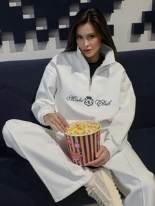 Detail of white fleece hoodie with Moda Club crest and metal half-zipper collar