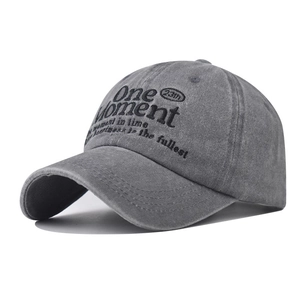 Detail view of the embroidered One Moment text on this vintage washed grey baseball cap