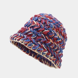 Close-up of thick mixed knit texture in red, blue, and beige on a wool bucket hat