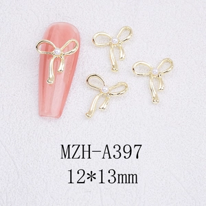 Macro shot of gold alloy bowknot nail charm with pearl inlay on long pink nail