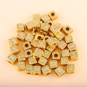 Macro detail of gold cube alphabet charms with micro-pave cubic zirconia for DIY bracelets