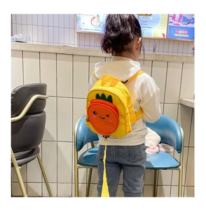 Detail view of toddler carrot backpack in yellow with safety leash on a child's back