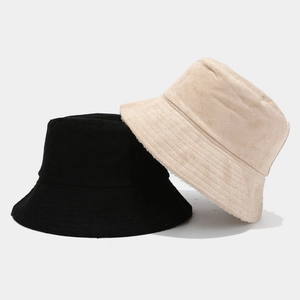 Detail of wide brim bucket hat showing black suede exterior and beige fleece lining