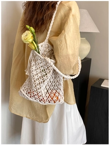Close-up of cream white macrame woven bag showing hollow rope grid and bohemian texture
