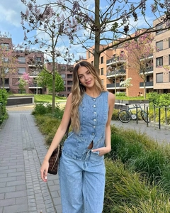 Detail of blue denim vest and high-waist wide-leg jeans in a washed cotton finish