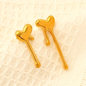 Polished gold plated stainless steel irregular liquid heart earrings on white fabric