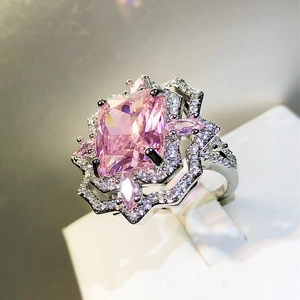 Macro detail of silver ring with square pink stone and floral double petal halo setting