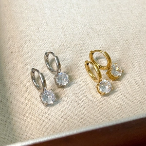 Detail view of gold and silver hoop earrings with sparkling round cubic zirconia pendants