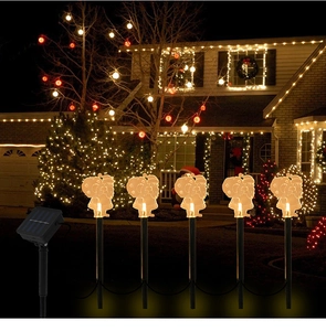 Set of 5 lighted Santa solar stake lights on a night lawn for outdoor Christmas decoration