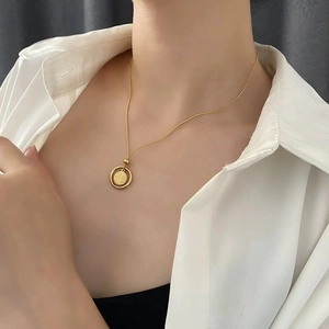 Gros plan détaillé d'un collier papillon double couche doré porté par un mannequin