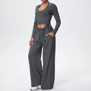 Détail de l'ensemble de yoga gris foncé avec haut cache-cœur et pantalon large fluide