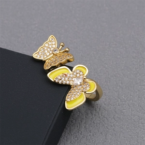 Detailed close-up of a double butterfly ring with yellow enamel and pavé zircons