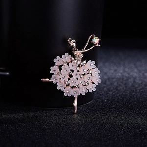 Macro shot of rose gold ballet dancer brooch with white flowers and crystal accents