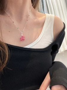 Detail of rose red balloon dog pendant necklace with colorful beads on silver chain