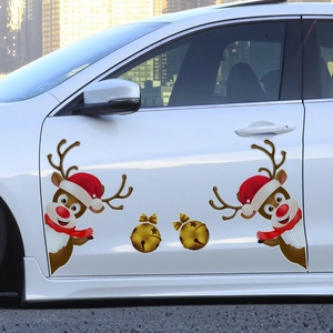 Close-up of reflective reindeer and bells magnetic stickers on white car door
