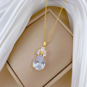 Élégant collier en titane doré avec pendentif cristal goutte sur tissu en soie blanche
