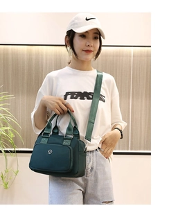 Detail of green nylon handbag showing handle texture and small circular logo accent