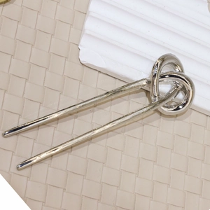 Polished silver U-shaped hair pin with minimalist twist knot design on elegant background