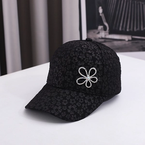 Detail of black baseball cap with 3D floral texture and sparkling rhinestone flower design