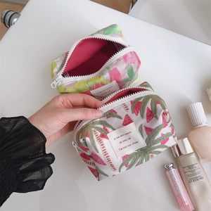 Close-up of tropical floral makeup bag with pink lining and secure zipper closure