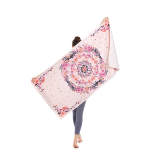 Pink microfiber beach towel with mandala pattern held by model on white background
