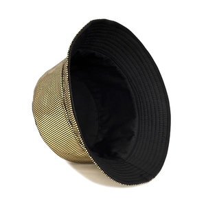 Detail of laser shiny gold grid texture and black lining on reversible bucket hat