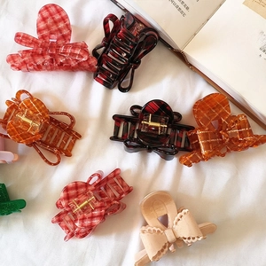 French style red checkered acetate bow claw clips and hair accessories on white fabric